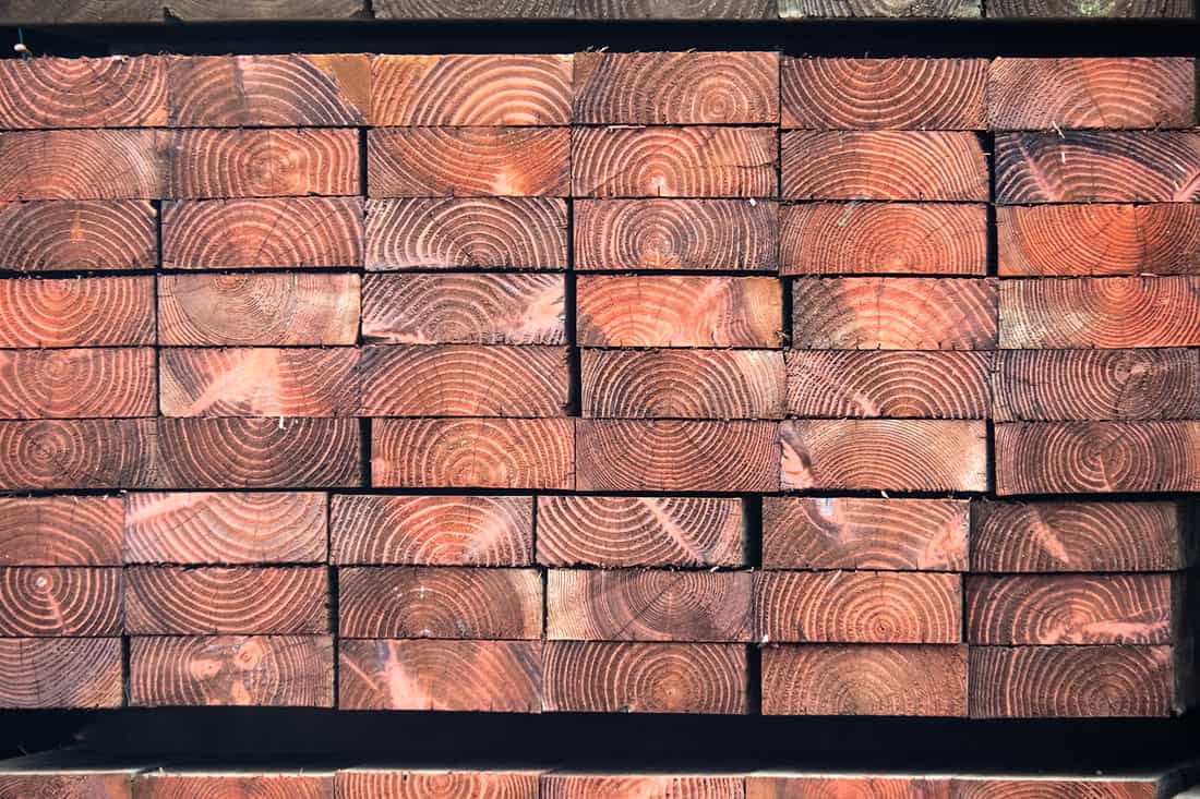 Close up of end grain of a pile of heavy industrial pressure treated wood planks