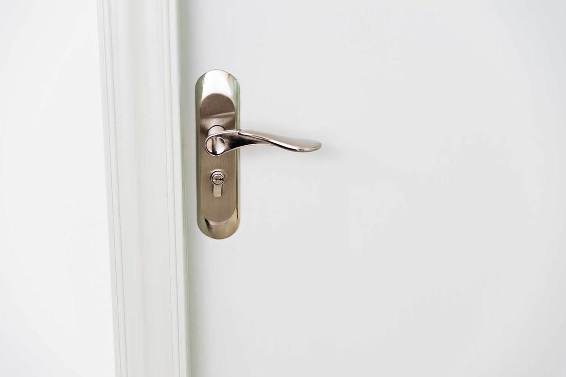 Close-up of white door with handle
