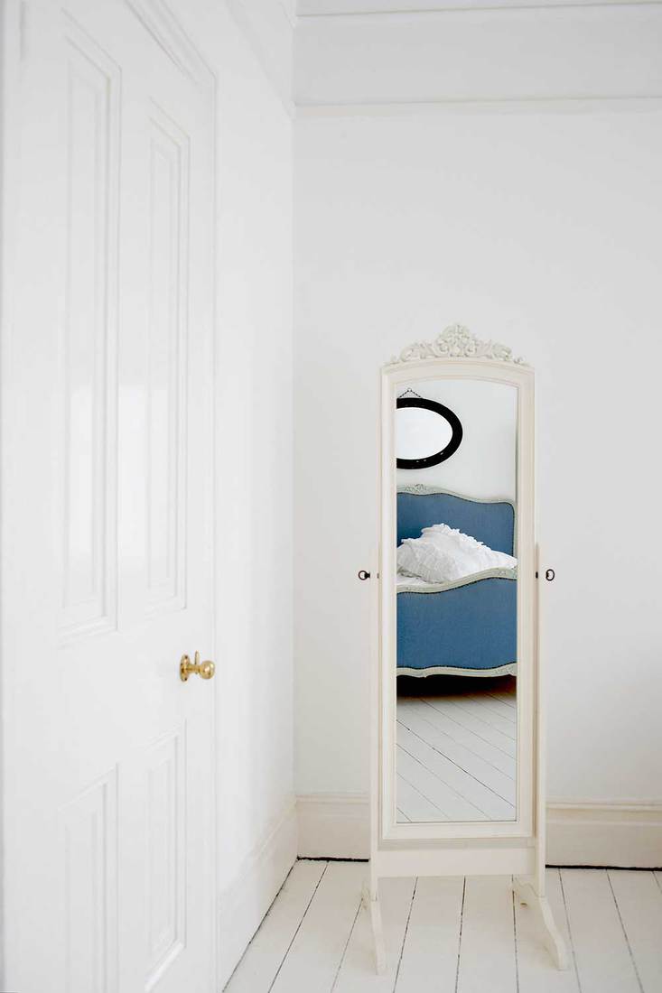 Empty bedroom with mirror and bed