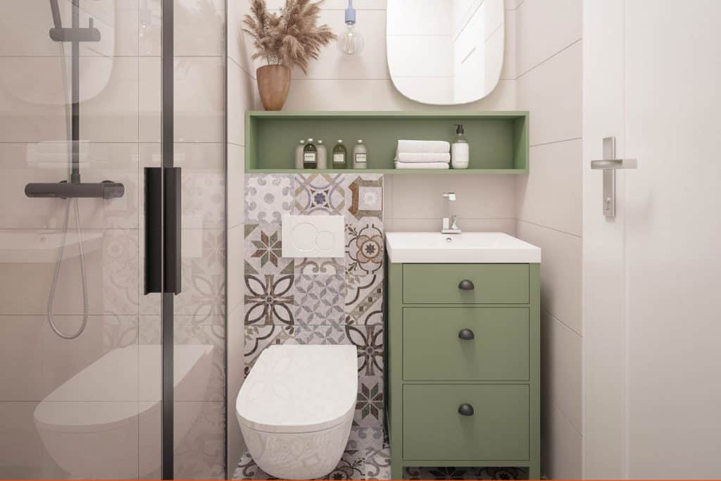 Green cabinet on the side of the toilet with a small long cabinet on top