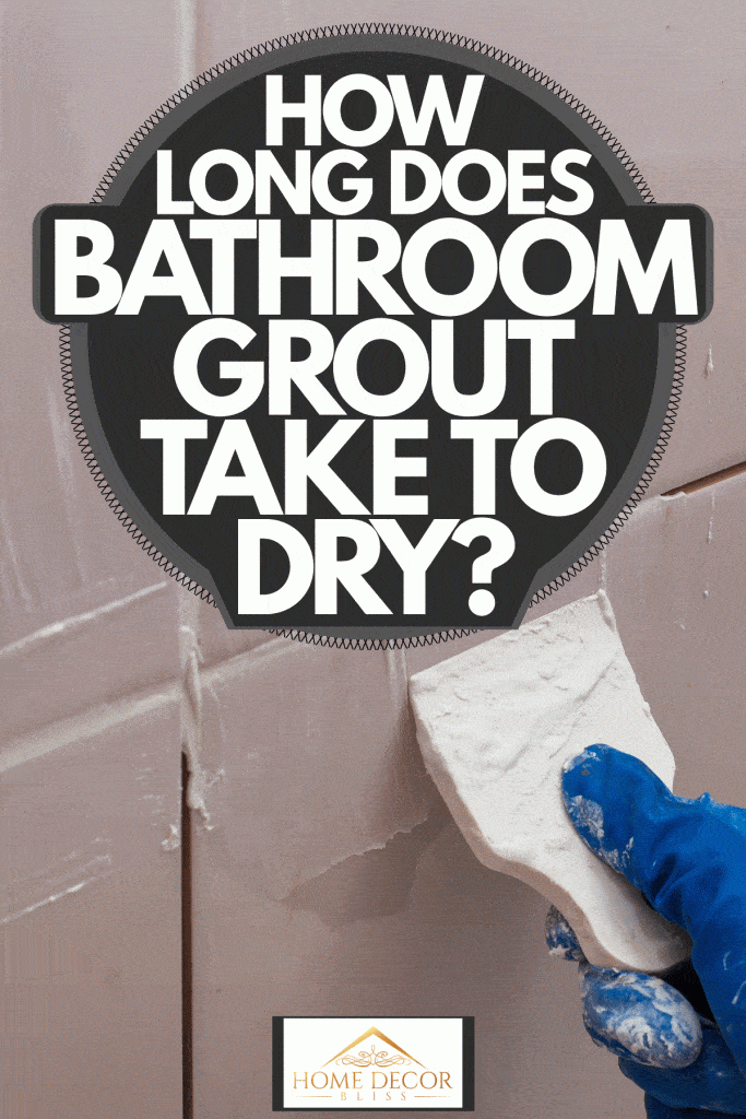 A tile setter putting grout on the tiles of bathroom, How Long Does Bathroom Grout Take To Dry?