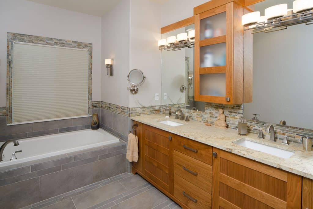 Interior of an elegant modern bathroom with wooden cabinetry on the vanity