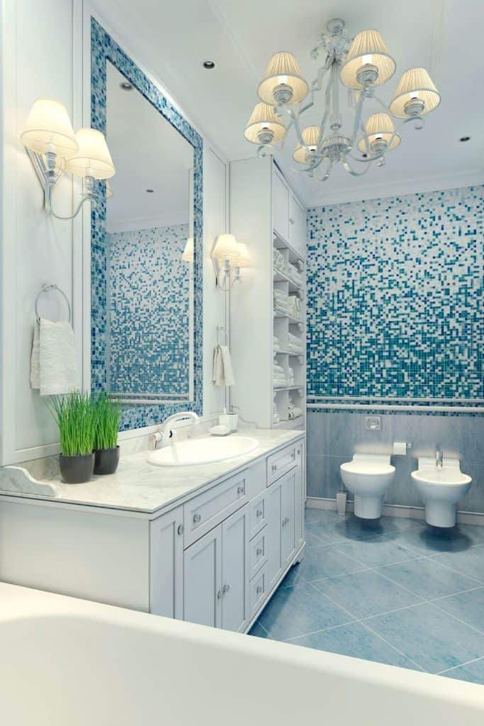 Interior of an arctic inspired bathroom with white paitned cabinetry and lighting all over the bathroom
