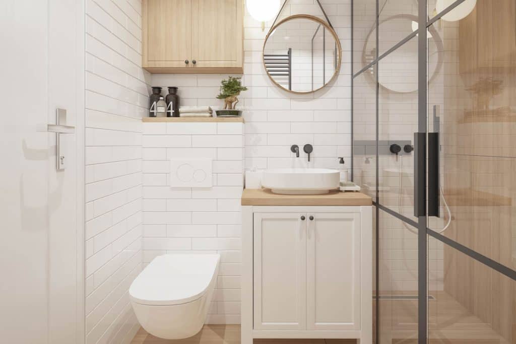 Interior of an ultra-white bathroom with wooden countertop vanity and a wooden cabinet on top