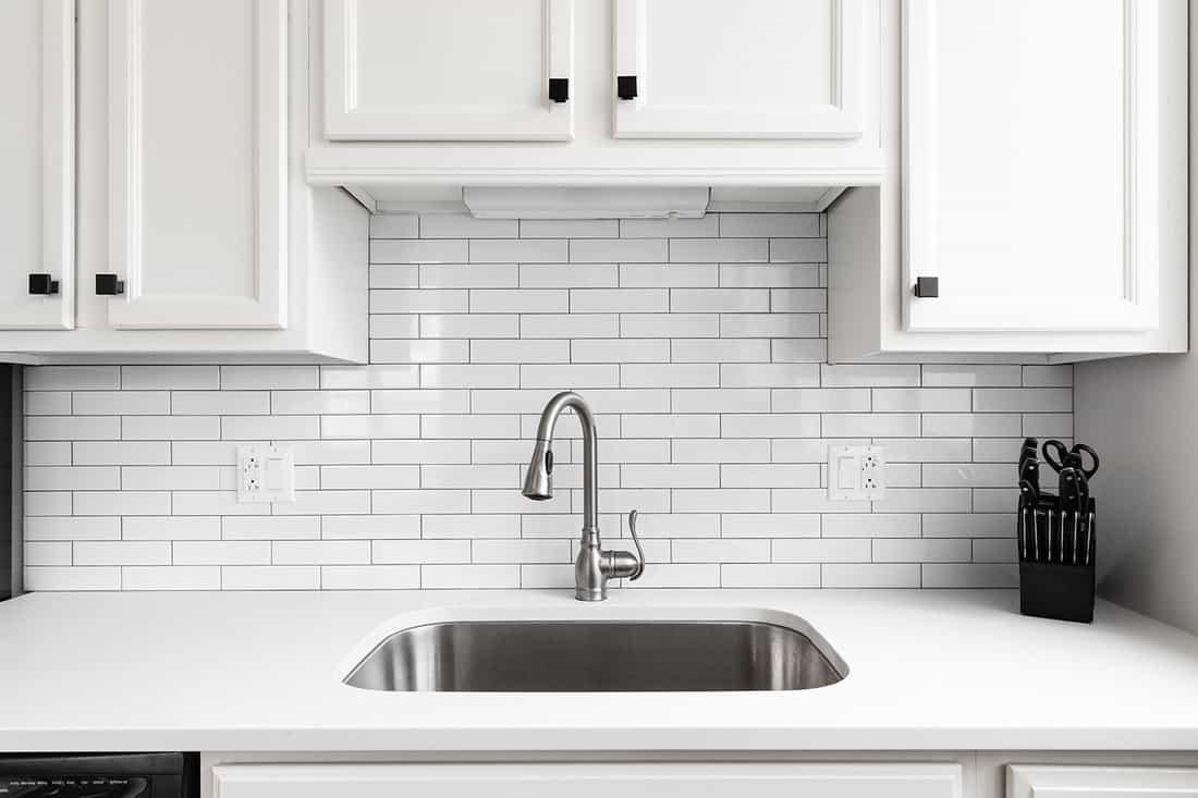 Kitchen sink detail shot with a subway tile backsplash