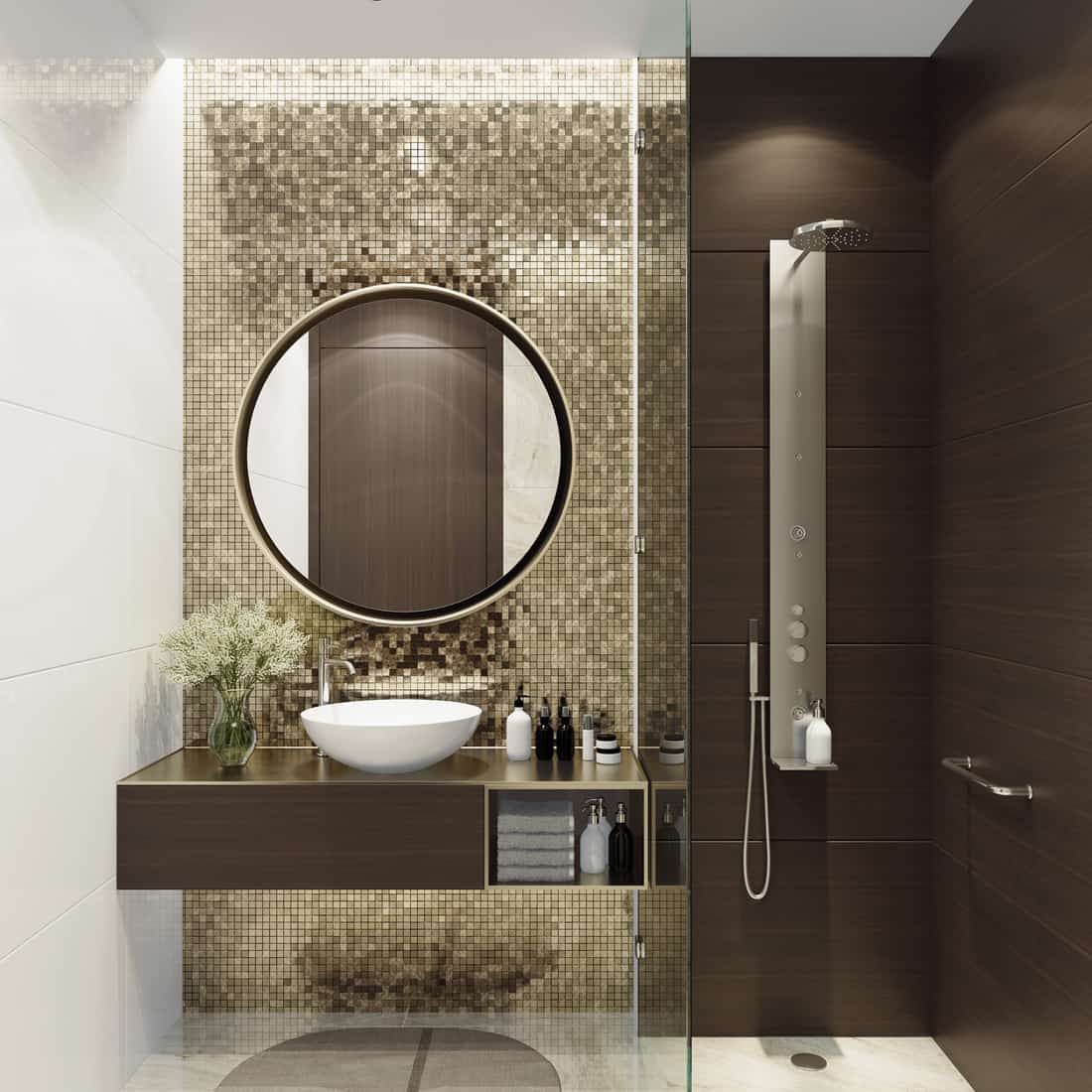 Luxurious bathroom with natural stone tiles and gold mosaic tiles. Round mirror. Small bathroom.