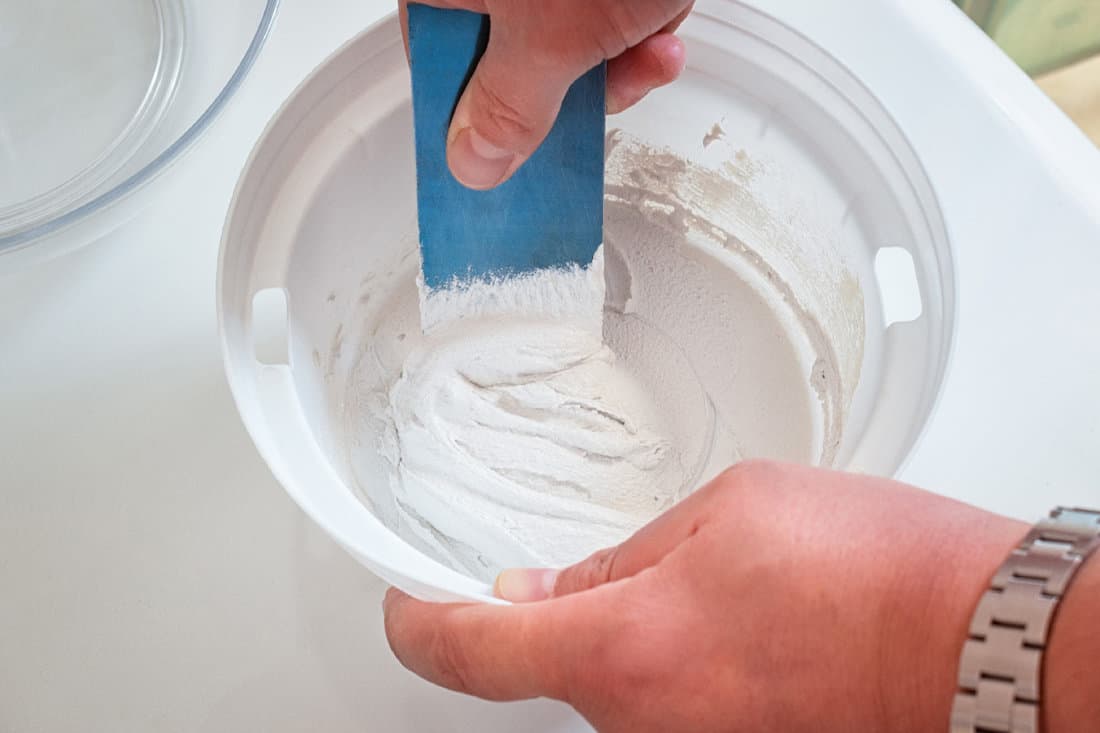Mixing two-component grout for house maintenance