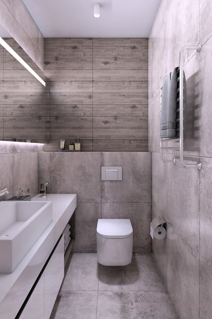 Modern bathroom interior with concrete textured wall, toilet seat, sink and wooden paneling wall in the background