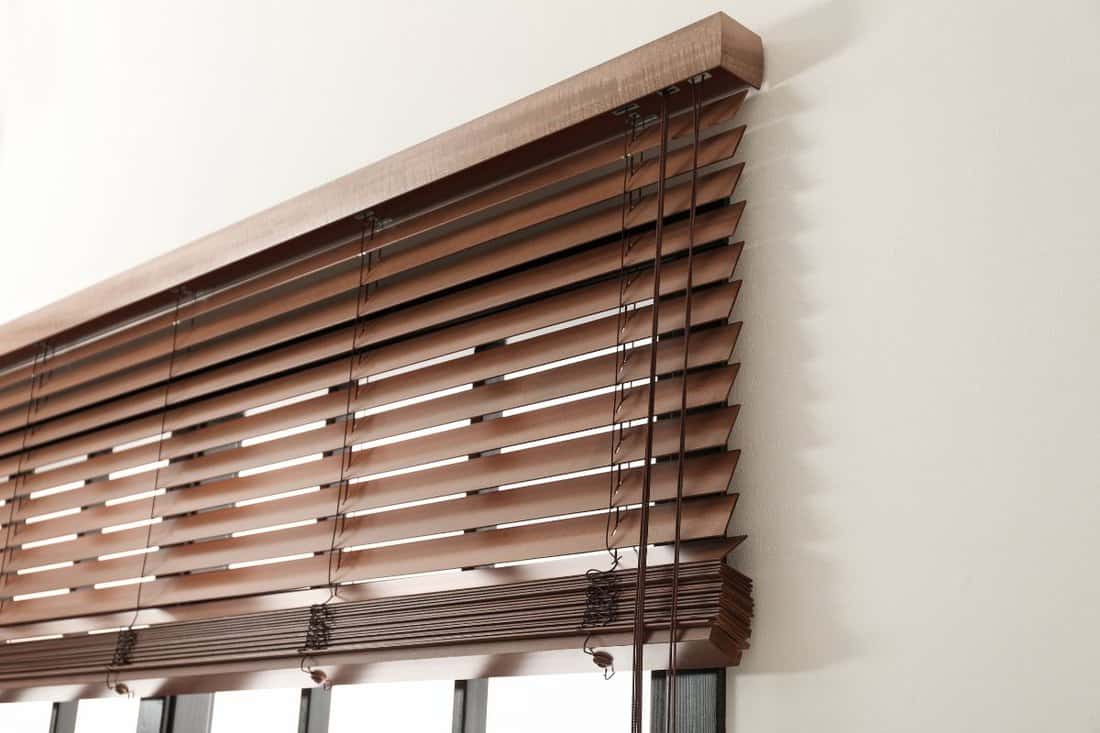 Modern window with stylish wooden blinds indoors