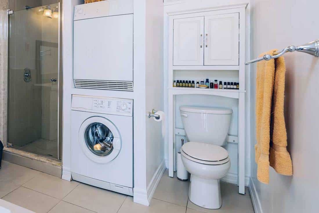 Rental condo main bathroom interior with washing machine, How High Should A Bathroom Cabinet Be Hung Over The Toilet?