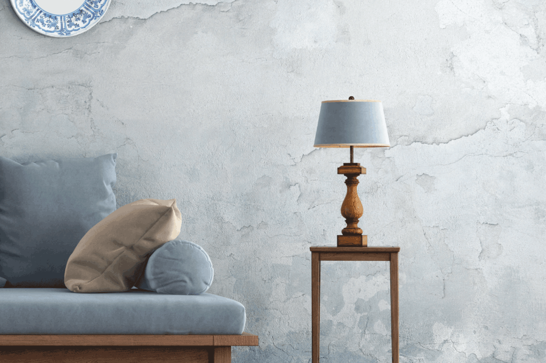 Retro living room with blue sofa against old wall and wooden paneling. end table with built-in lamp on the side. 11 Awesome End Tables With Built-In Lamps