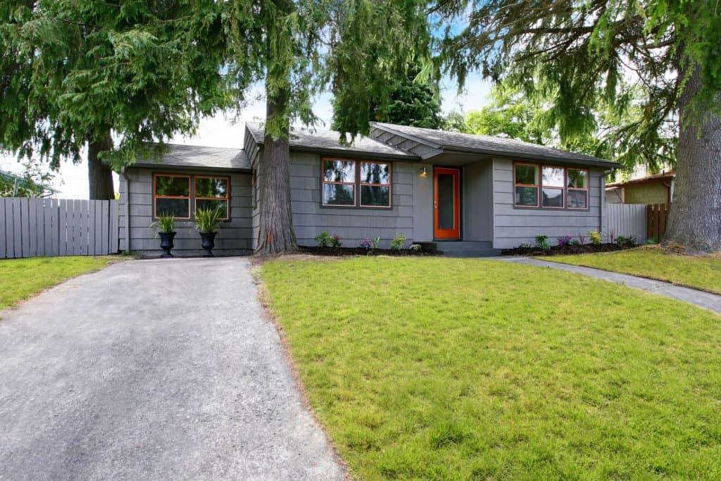 Stunning gray single storey ranch house with polished windows, orange front door, and gray roofing