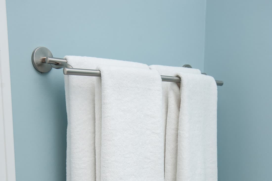 Two towels hanging on the Clothes line.Clean white towels on a hanger.white towel in bathroom, home.Bathroom Towel - white towel on a hanger prepared to use 
