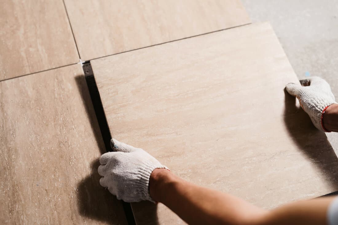 Tiler laying the ceramic tile on the floor