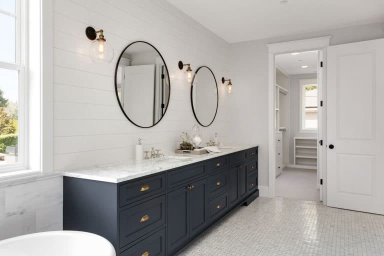 Ultra modern bathroom painted in white tiles, round mirrors, white gray cabinetry in the vanity section, and small lamps on the walls, What Wall Color Goes With A White Bathroom Floor?