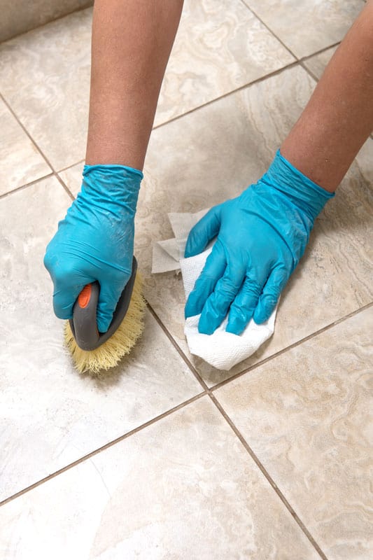 Woman scrubbing the tile grout