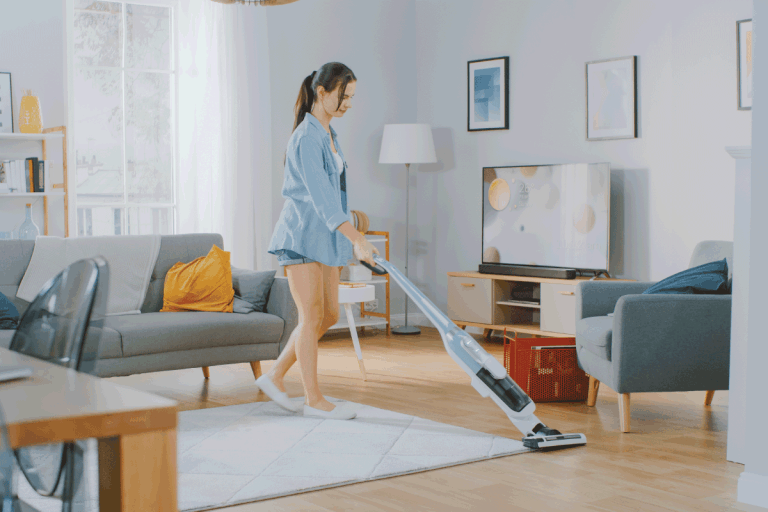 Young Beautiful Woman in Jeans Shirt and Shorts is Vacuum Cleaning a Carpet in a Bright Cozy Room at Home. Can You Use A Bissell Crosswave On Vinyl Or Laminate Flooring