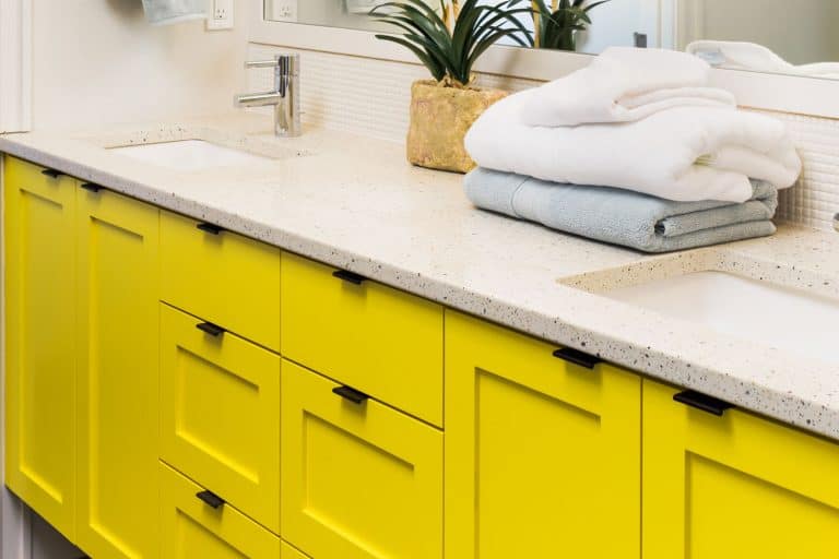 detail closeup of sink, faucet, countertop,yellow cabinets, and mirror, 15 Awesome Bathroom Cabinets Color Ideas