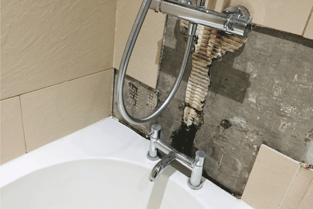 falling tiles and grout above the faucet and shower on a bathtub