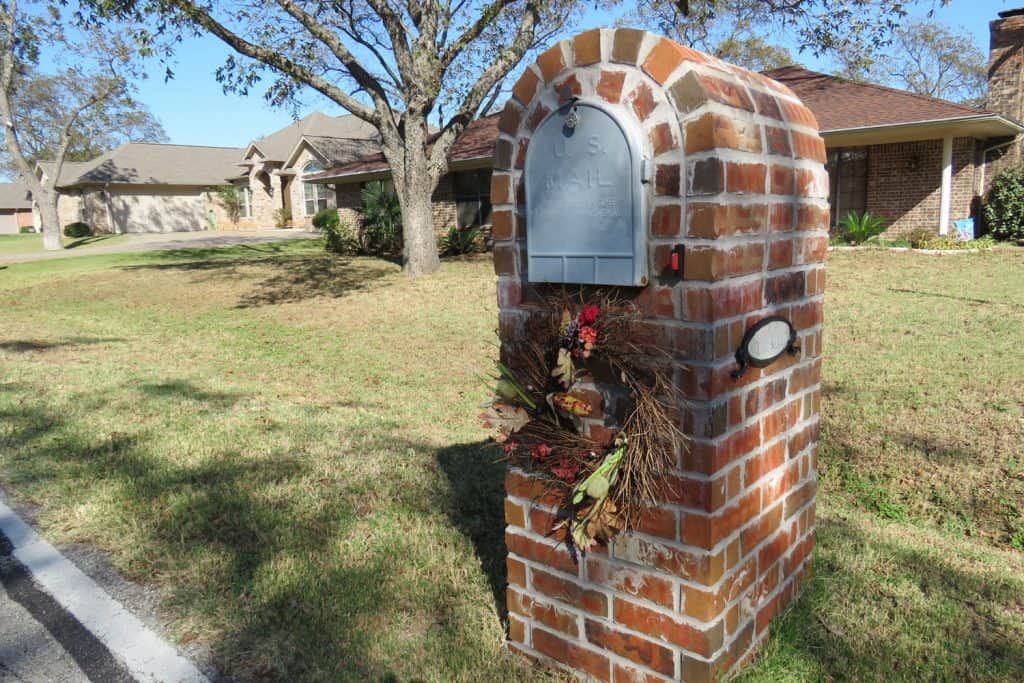 A brick structured mailbox placed on the front lawn