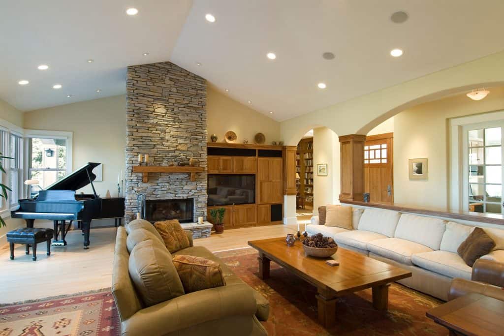 A luxurious interior of a modern rustic house with recessed lighting, a huge carpeted flooring, and contrasting colors of furniture's