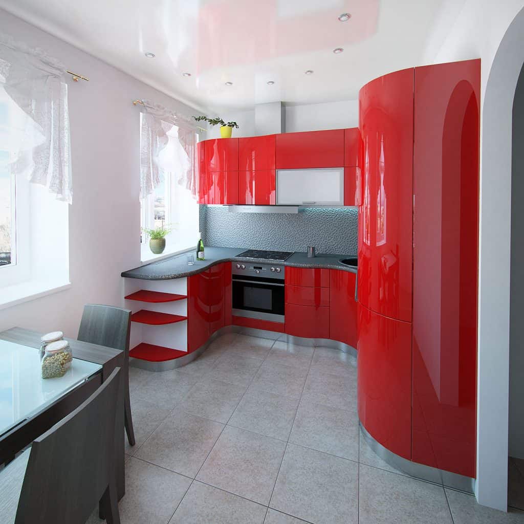 A modern retro inspired kitchen with red metal cabinetry and a red curved refrigerator door