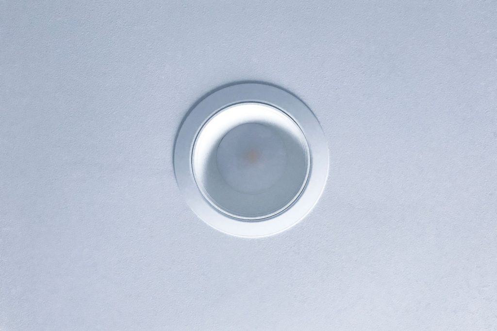 An up close photo of a recessed lighting can on the ceiling
