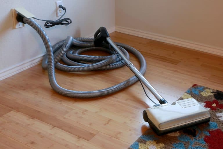 Beautiful bamboo hardwood floor and wool rug with a central vacuum cleaner attached to the wall, Central Vacuum Not Turning On -What Could Be Wrong?