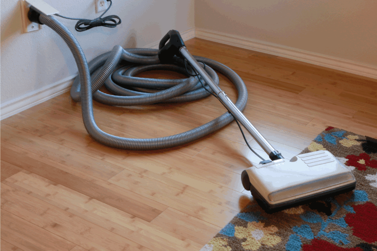 Beautiful-bamboo-hardwood-floor-and-wool-rug-with-a-central-vacuum-cleaner-attached-to-the-wall.-How-To-Remove-A-Central-Vacuum-From-The-Wall