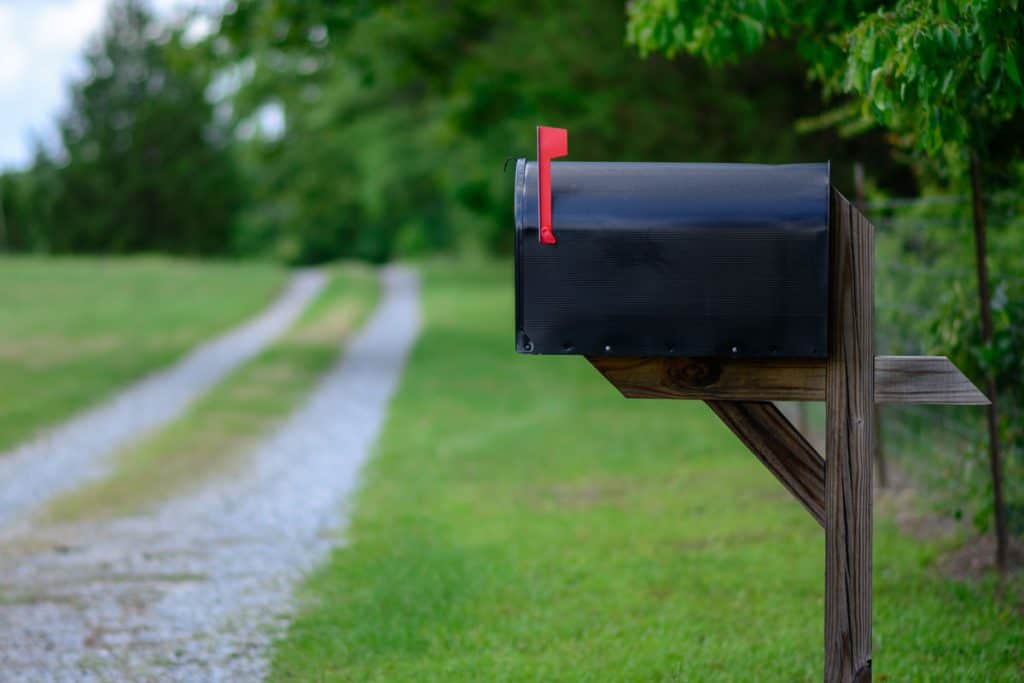 Black mailbox mounted on a wooden post