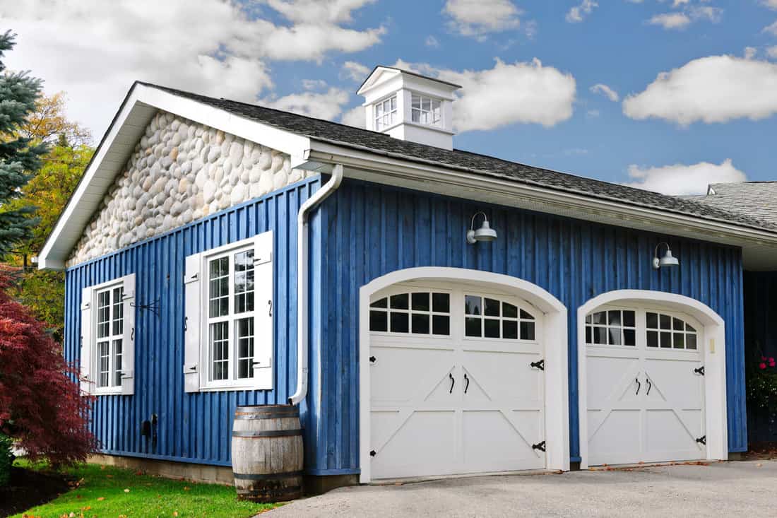 Double car garage with white doors and blue exterior