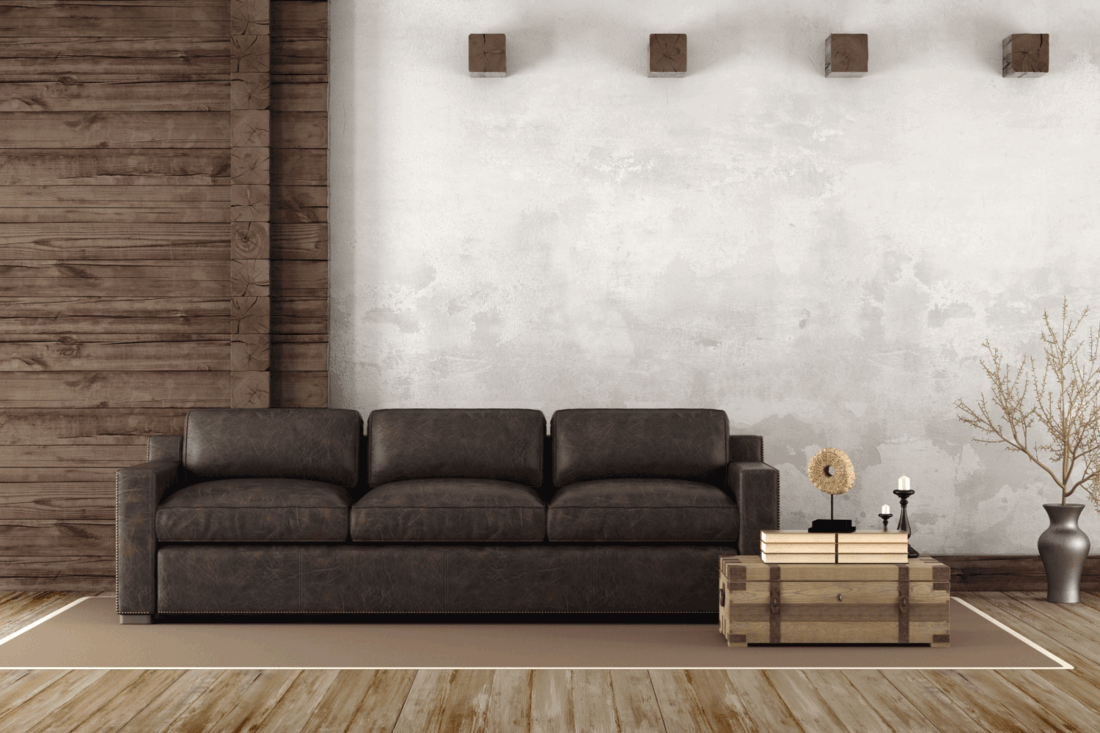 Home interior in rustic style with leather couch and old wooden paneling