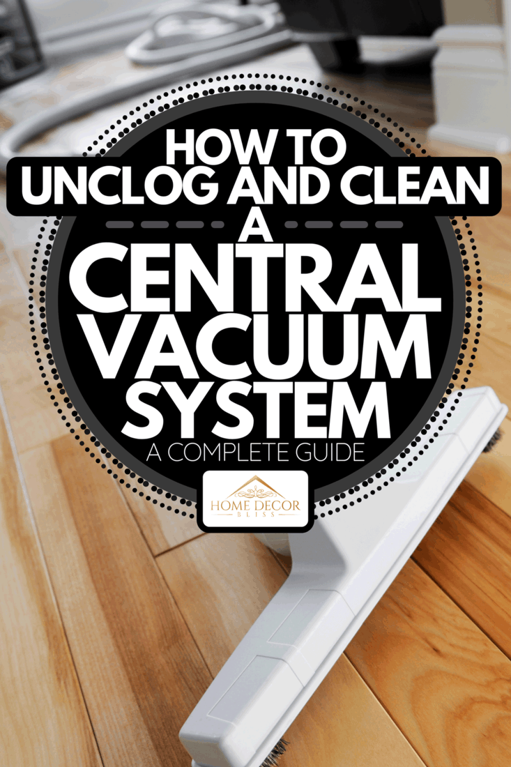 A central vacuum brush and hose on a hard wood floor inside a home, How To Unclog And Clean A Central Vacuum System [A Complete Guide]