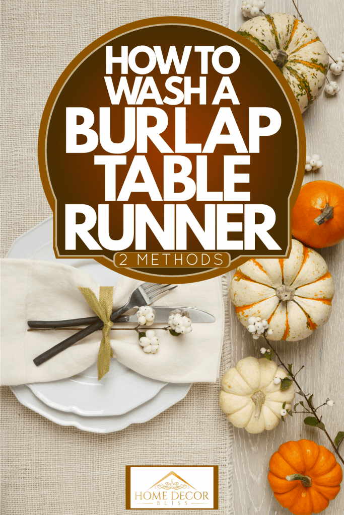 A white burlap table runner decorated with a plate and pumpkins on the table, How To Wash A Burlap Table Runner - 2 Methods