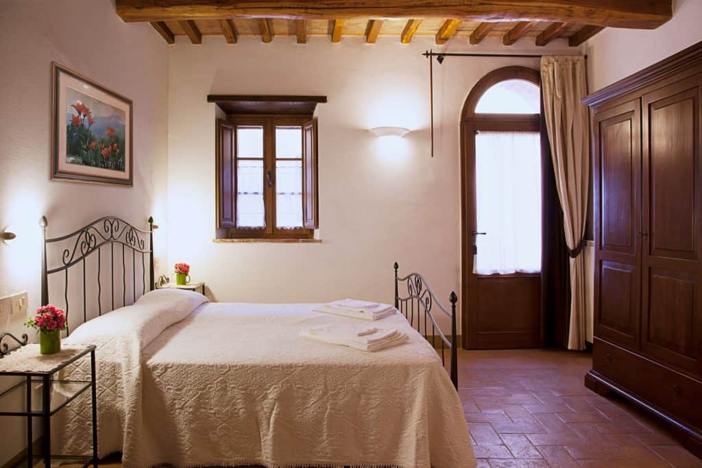 Interior of a Tuscany inspired bedroom with wooden window and door framing