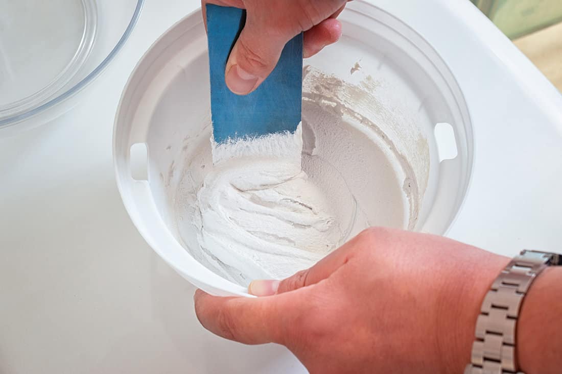 Mixing two-component grout for house maintenance
