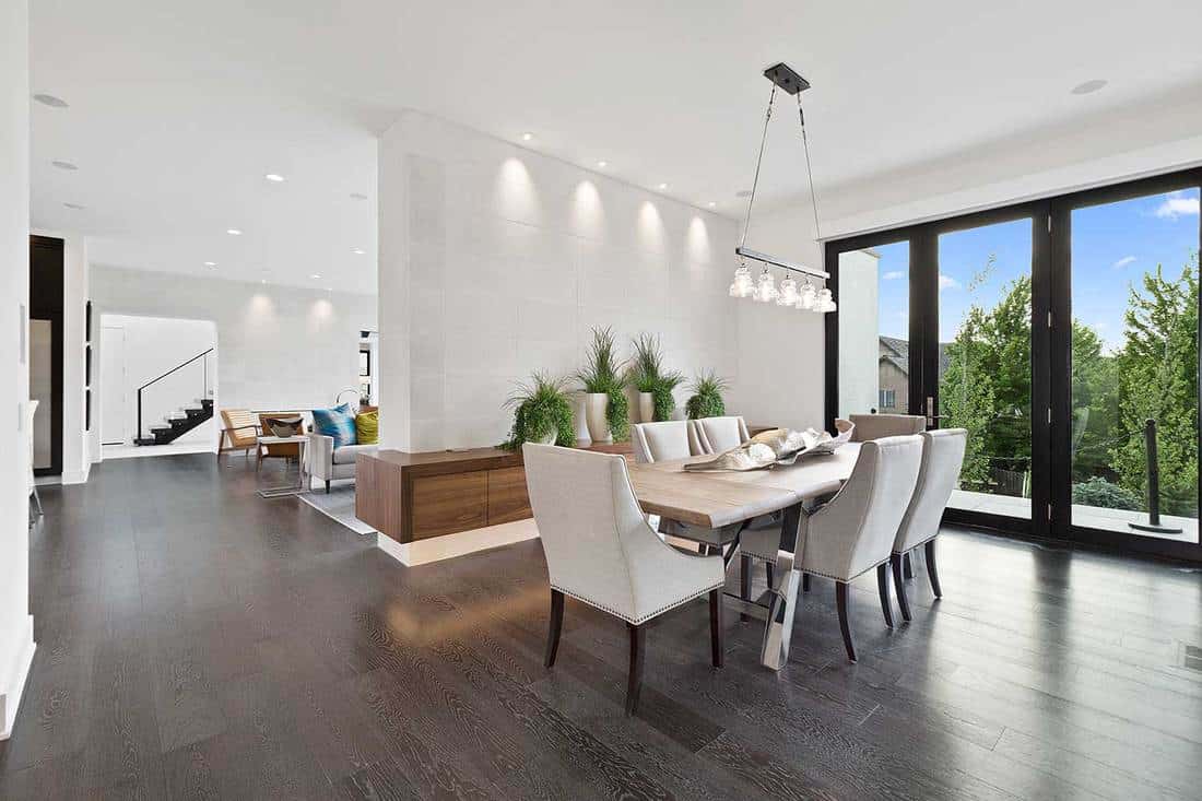 Modern home with stylish furnishings in dining room, white walls and beautiful clear glass doors