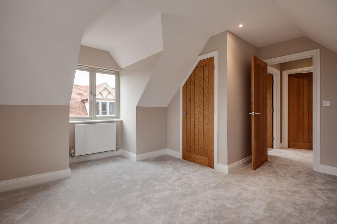 Modern unfurnished bedroom with sloping ceilings and built in wardrobe within brand new recently completed new home