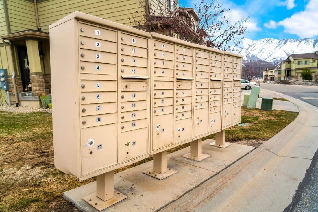 Residential mailboxes with numbered compartments on the side of a road