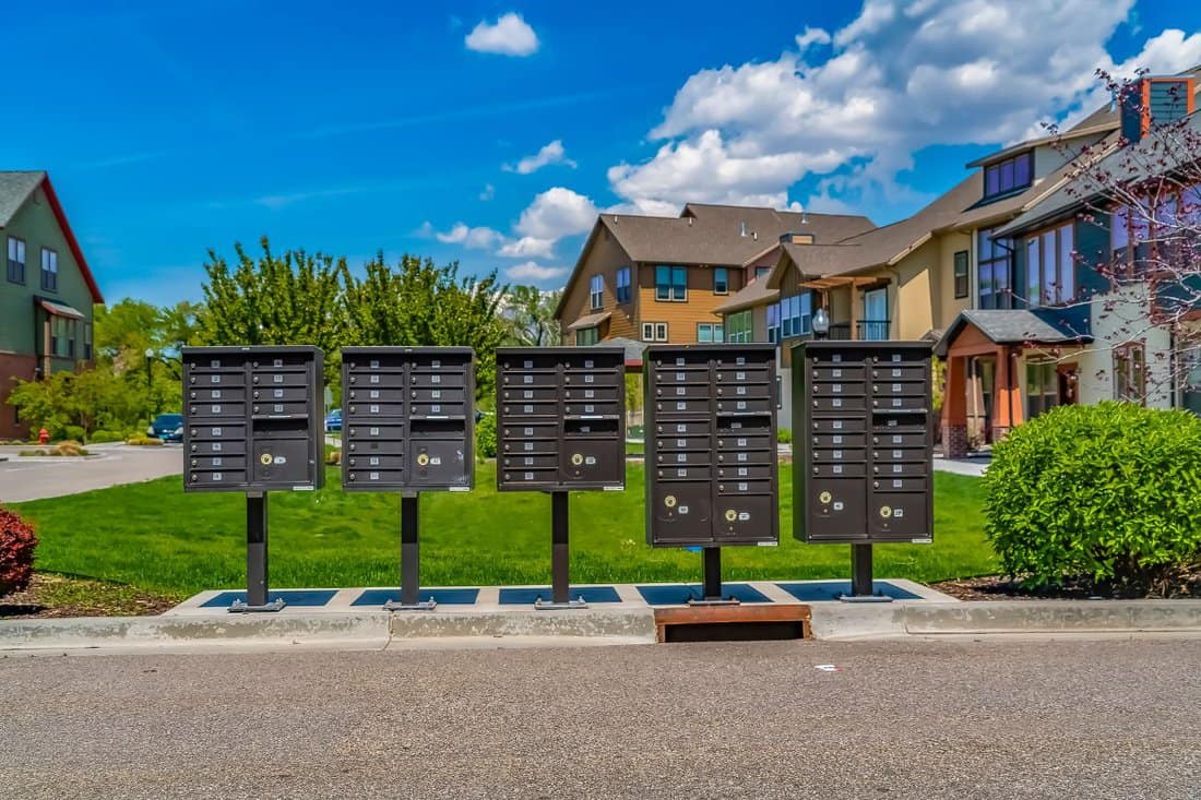Row of cluster mailboxes with numbered compartments on the sidewalk