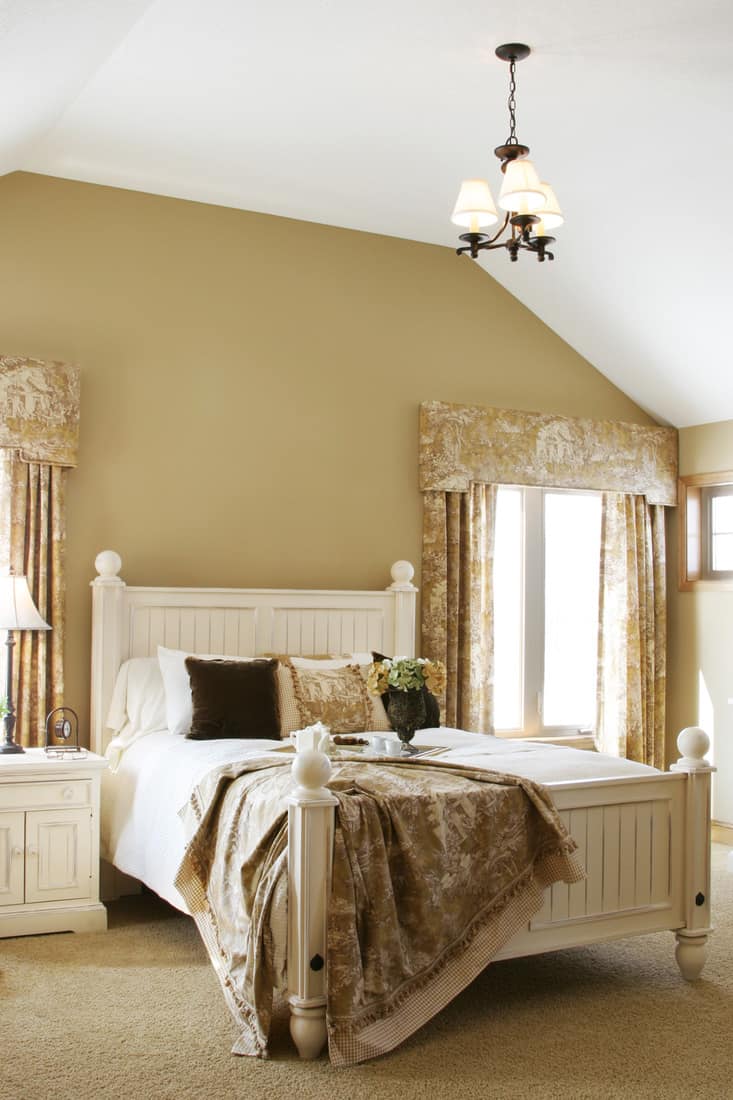 Vertical view of a gorgeous french country master bedroom suite in an upscale showcase home