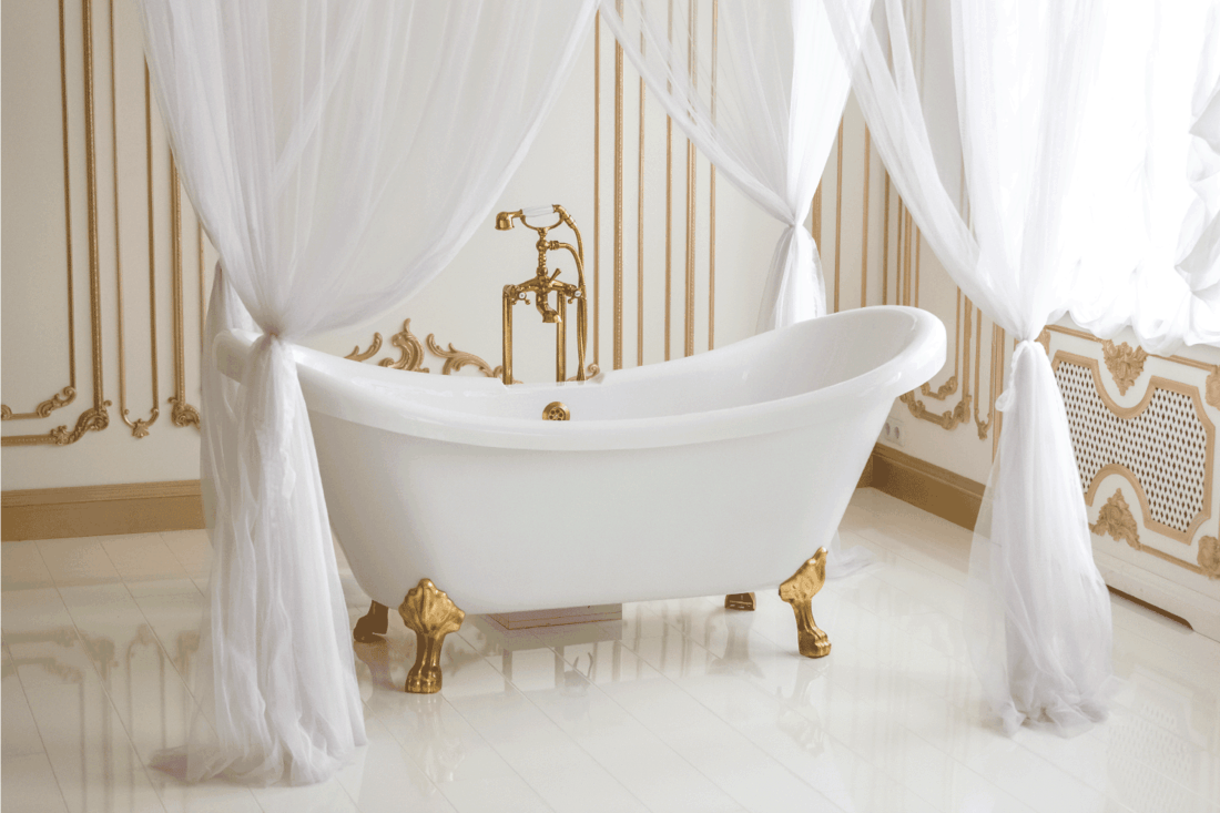 White luxurious bath with golden legs at bathroom. Clawfoot bathtub