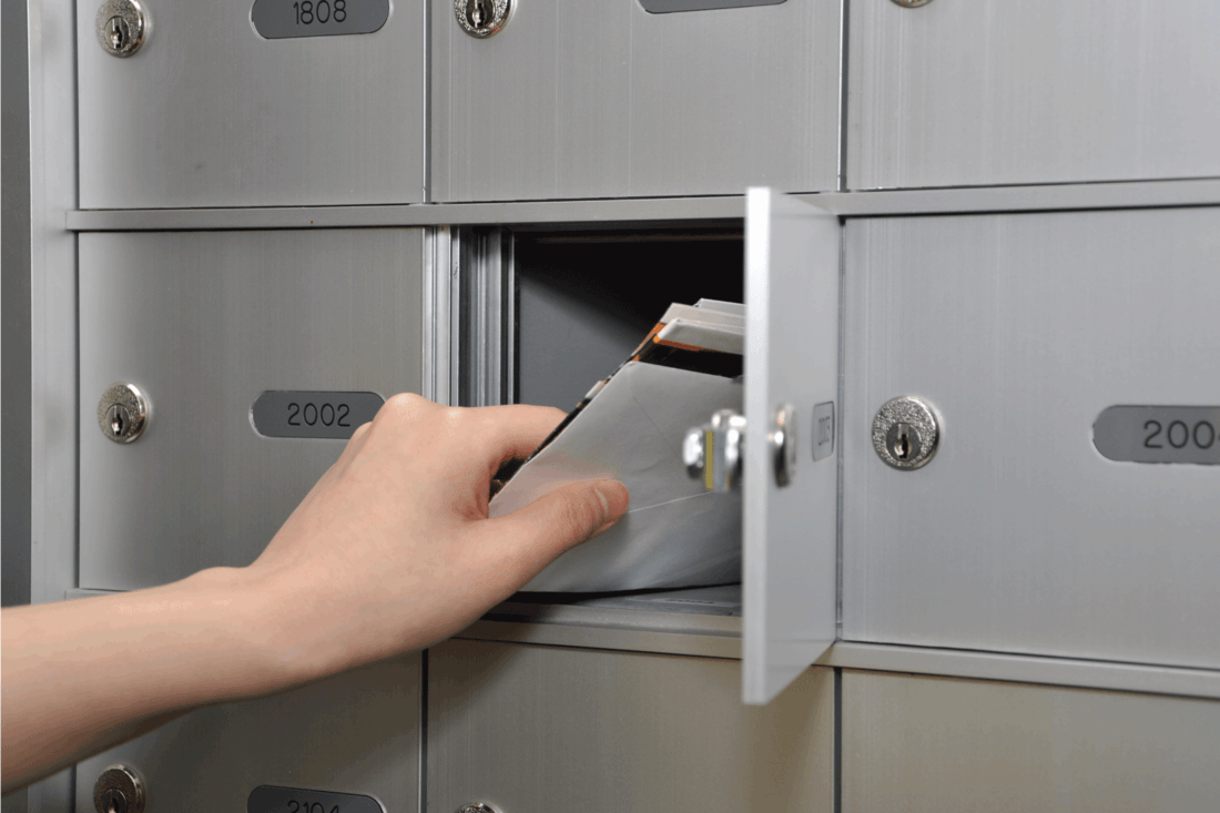 hand pulling out mail from mailboxes