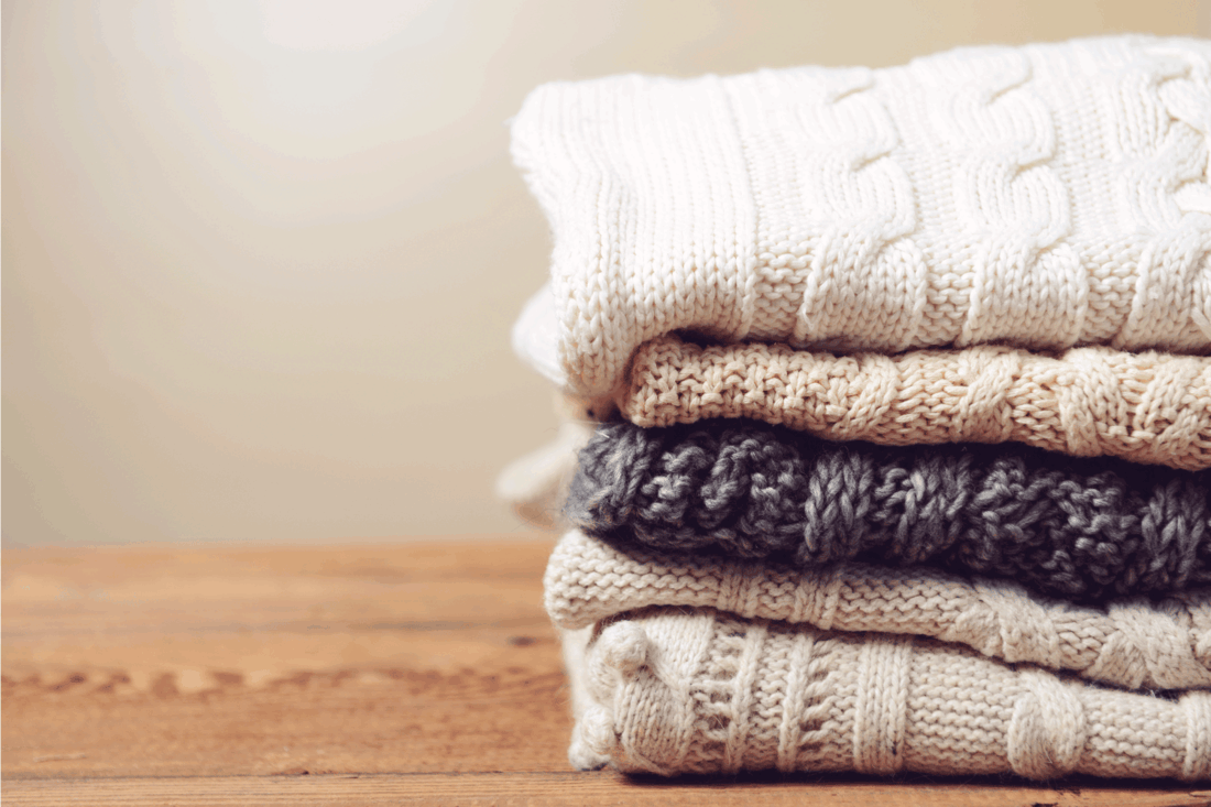 stack of sweaters on a wooden table