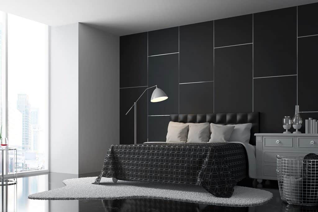 A luxurious interior condominium bedroom with black painted backsplash, gray ceiling, and black beddings