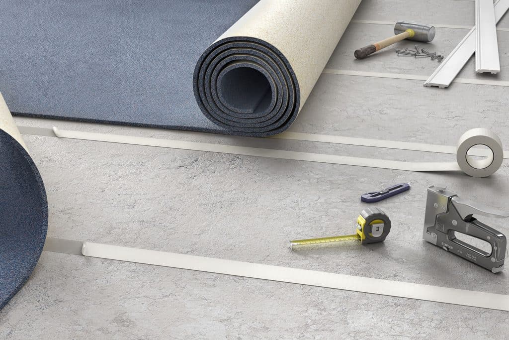 Carpet installation equipment's and an unrolled gray carpet padding