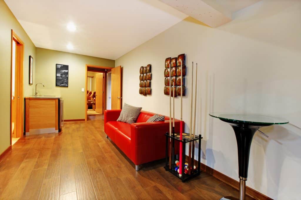 Hallway with billiard poll and red sofa near the small bar.