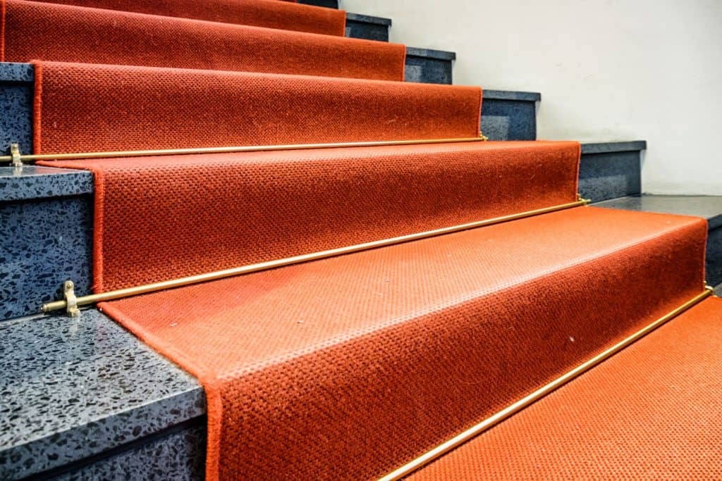 Luxuiorus marble stairs with a light orange carpet runner
