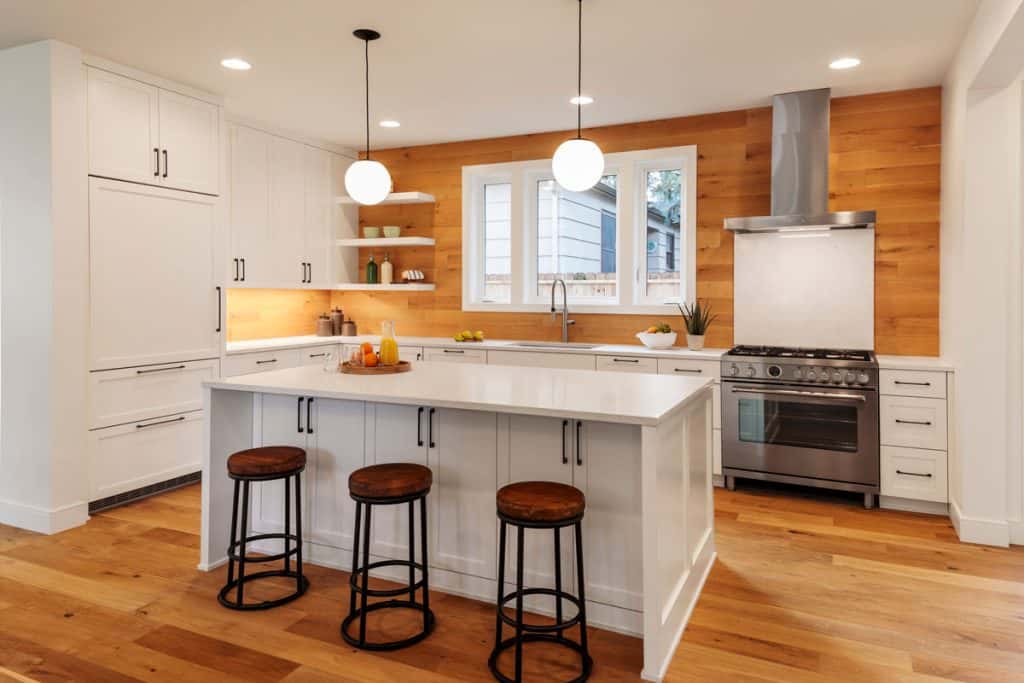 Luxurious kitchen interior with white painted walls, recessed lighting, and a breakfast bar
