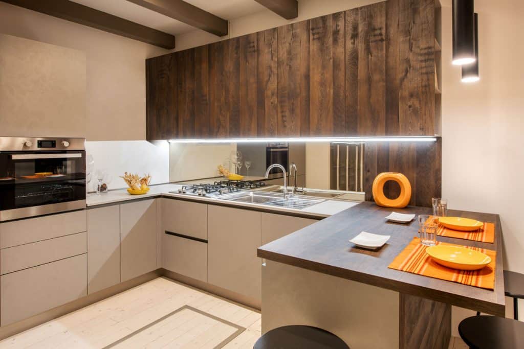 Luxurious minimalist themed kitchen with ambient lighting, wooden cabinets and wooden countertop